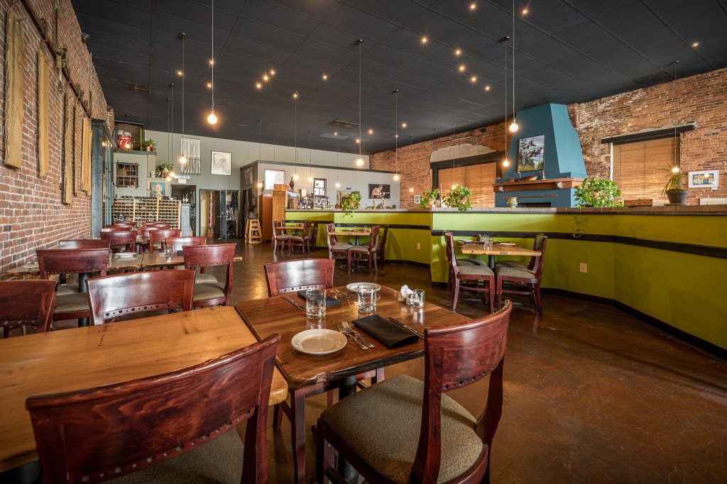 Dining area with green wall and wooden tables and chairs