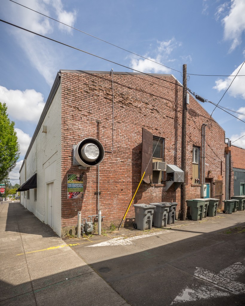 Brick wall with hood vent, alley and side of building