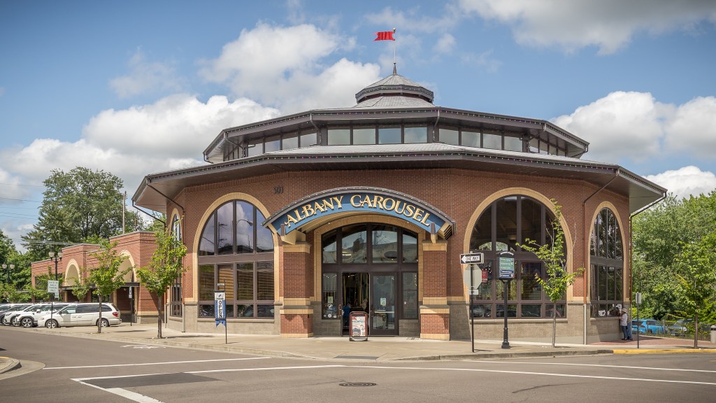 Round red brick building with arched windows and door and street light posts