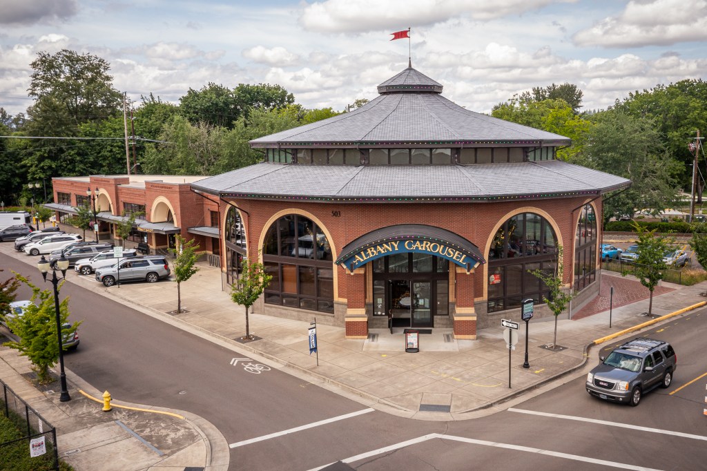 Round red brick building with arched windows and entry